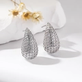 Macro shot of silver teardrop earrings with detailed pavé cubic zirconia settings - White