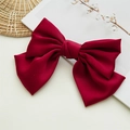 Detailed view of a large red satin bow hair clip with glossy texture and elegant design - Burgundy