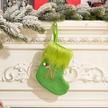 Green knitted Christmas stocking with letter N hanging on a festive decorated fireplace - Letter N