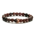 Detail of rose gold crown charm on pink and black natural stone beaded bracelet - Rhodonite