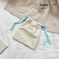 Détail macro d'une trousse en velours côtelé fleuri avec cordon bleu et étiquette tissée - Velours Côtelé Floral Bleu