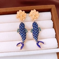Macro-detail van vergulde koi-oorbellen met blauw emaille en fonkelende strass-steentjes - Zilveren oorknopje - Goud - Blauw / Blauw