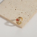 Bague dorée ajustable avec pierre orange ovale sur un socle en pierre beige - Style Zircone Orange