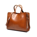 Detailed shot of brown PU leather tote bag with dark metal hardware and adjustable strap - Brown