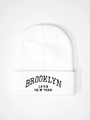 Close-up of white ribbed knit beanie featuring black Brooklyn 1898 embroidery on cuff - One Size / White