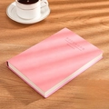 Pink A5 faux leather notebook with notebook text on a wooden desk with a coffee cup - Ruled / A5-Pink