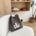 Detail of dark grey tote bag with cat illustrations on a cozy white texture chair - Grey Happy Cat