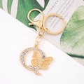 Detail of a gold butterfly keychain with sparkling rhinestones on an elegant card - Letter Q