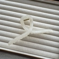Close-up of cream marble hair claw clip with golden spring on velvet jewelry tray - White Cross 13cm
