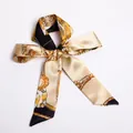 Baroque chain print skinny silk scarf in black and gold tied as a decorative bow - S23-Black Gold Baroque Chain
