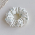 Detail of white fabric scrunchie with green floral pattern and soft pleated texture - Green Floral