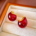 Detailed close-up of red resin water drop earrings with golden metal settings in box - Red Amber Waterdrop Stud Earrings (HE17677)