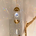 Golden suncatcher with moon phases and crystal prisms creating rainbow light patterns - B14 Style