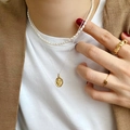 Nahaufnahme eines Set aus goldener Smiley-Kette, Perlenkette und gewebtem Goldring-Set - Dreifarbig (Gold/Silber/Roségold)