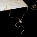 Détail d'un collier en Y doré avec curseur en zircone et perles dorées suspendues - Style Boule Zircone / Doré