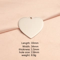 Polished silver heart pendant 33mm in stainless steel on soft peach silk fabric - Steel Color Outer Hole Pendant