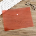 Translucent red A4 plastic file folder with white snap button on wood desk - 18 Microns Red Plain