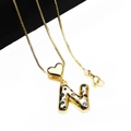 Detailed close-up of gold letter N pendant with colorful zircons and heart charm - Pendant with Necklace / Letter N