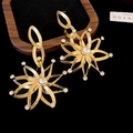 Gros plan de boucles d'oreilles tournesol dorées avec cristaux sur velours - Style Tournesol Strass (8) / Or