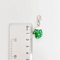 Detail van groene kersthanschoen hanger met karabijnsluiting naast een liniaal voor maat - Groene Sneeuwvlok Want Hanger