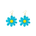 Détail des boucles d'oreilles marguerites en raphia tissé bleu et jaune avec crochets dorés - Bleu