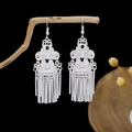 Ethnic silver-tone dangle earrings with long metal tassels hanging on a wood branch - Complex Hollow Carved Tubular Tassel Style (E2344)