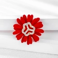 Detail of red floral daisy brooch with sparkling crystal center on a white pedestal - Red Rhinestone Daisy