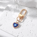 Detailed close-up of golden heart evil eye keychain with blue enamel and rhinestones - Gold Enamel Heart Evil Eye