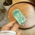 Detail showing mint green and cream marble acetate hair claw clip with gold lettering - Green Bubble