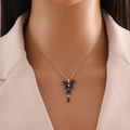 Elegante collana dorata con ciondolo a farfalla in pietra blu su una catena delicata - Blu Reale