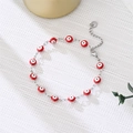 Close-up of a silver evil eye charm bracelet with red beads and lobster clasp detail - Red Eyes Silver
