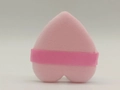 Detail of pink heart-shaped powder puff with ribbon handle and plush texture - Pink
