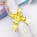Close-up of bright yellow plastic gift bow with gold edges for festive packaging - Yellow Gold Edge