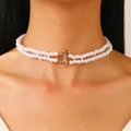 Collier double rang en perles blanches avec nœud doré porté par un mannequin femme - Collier de Perles Artificielles Double Rang avec Noeud (5336)