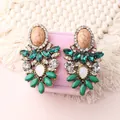 Macro view of vintage bohemian earrings with green crystals and marble stones on jewelry box - Dark Green