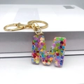 Detail of uppercase M keychain with colorful heart sequins in transparent resin charm - Letter M Lobster Clasp Keychain