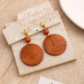 Macro detail of geometric wooden drop earrings on stone and light wood background - E5516-3 (Brown Large Round)