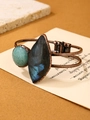 Macro detail of vintage copper bangle with blue labradorite and green amazonite stones - Labradorite + Amazonite