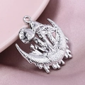 Detailed close-up of a silver crescent moon and mushroom charm on soft satin fabric - Silver