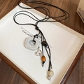 Détail d'un collier bohème avec anneau blanc et cœur argenté sur plateau en bois - 10# Collier-Blanc (Anneau Blanc/Coeur)
