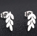 Macro shot of polished silver leaf-shaped stainless steel stud earrings on black background - Steel