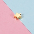 Macro shot of a golden star-shaped metal bead showing threading hole for DIY jewelry - 7.5x8mm Star / 18K Gold Plated