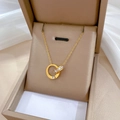 Collar de acero de titanio con doble anillo entrelazado y pavé de circonitas finas - Dorado