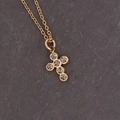 Macro shot of a golden cross necklace pendant with sparkling rhinestones on dark slate - Grey Cross Shape
