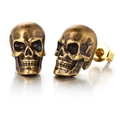Macro shot of vintage bronze skull earrings with detailed gothic distressed texture - Vintage Gold