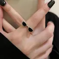 Close-up of a silver ring with a creative black enamel sunglasses design on a finger - Silver - Sunglasses Cool Style