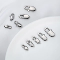 Macro view of polished stainless steel lobster clasps in various sizes for DIY jewelry - 11x6mm / Steel Color