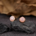 Macro shot of S925 silver stud earrings with pink gemstone on dark stone background - Natural Pink Opal Round Gold 5mm