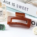 Medium amber brown jelly square hollow hair claw clip for women on a white background - Jelly Brown