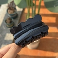 Detail showing wave-shaped edges and glossy black plastic finish of the shark hair clip - Black (Glossy)